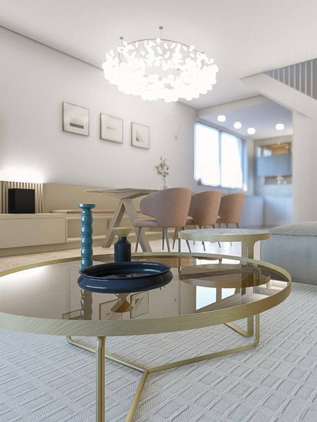 Štýlová obývacia izba so zlatým konferenčným stolíkom spojená s jedálňou a kuchyňou. Interiér s prvkami elegancie a glamour.