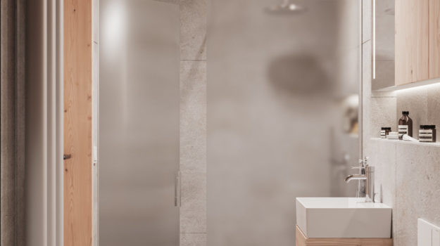 Návrh kúpeľne so sprchovacím kútom s matovaným sklom. Drevený nábytok vytvára príjemný kontrast k betónovým povrchom.